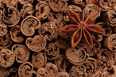 Photo of Aromatic cinnamon sticks and anise as background, top view