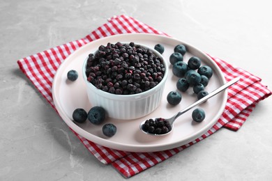 Photo of Freeze dried and fresh blueberries on light grey table