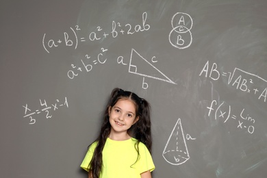 Little school child and mathematical formulas on grey background