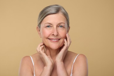 Photo of Portrait of senior woman with aging skin on beige background. Rejuvenation treatment