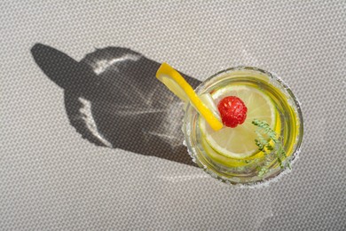 Delicious refreshing lemonade with raspberries on light gray rattan surface, top view. Space for text