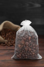 Scented sachet with coffee beans on wooden table, closeup