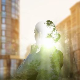 Double exposure of businesswoman and green forest in city