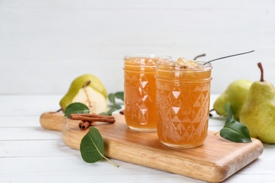 Delicious pear jam and fresh fruits on white wooden table. Space for text