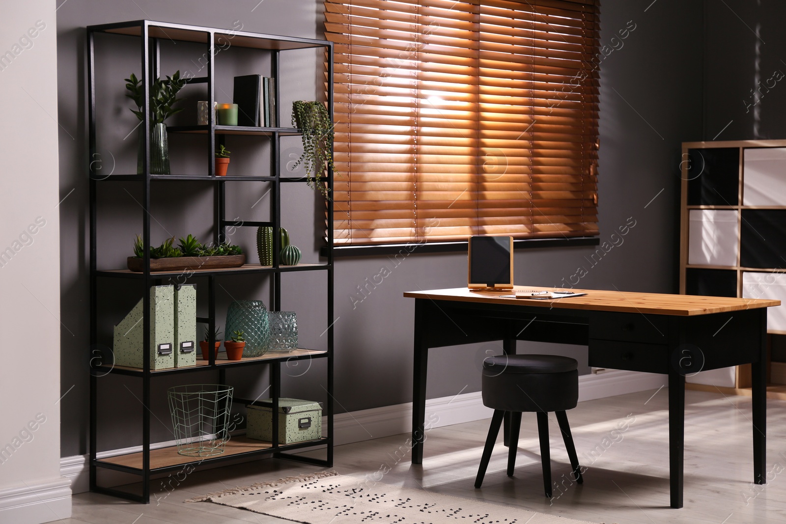 Photo of Stylish room with shelving and table. Interior design