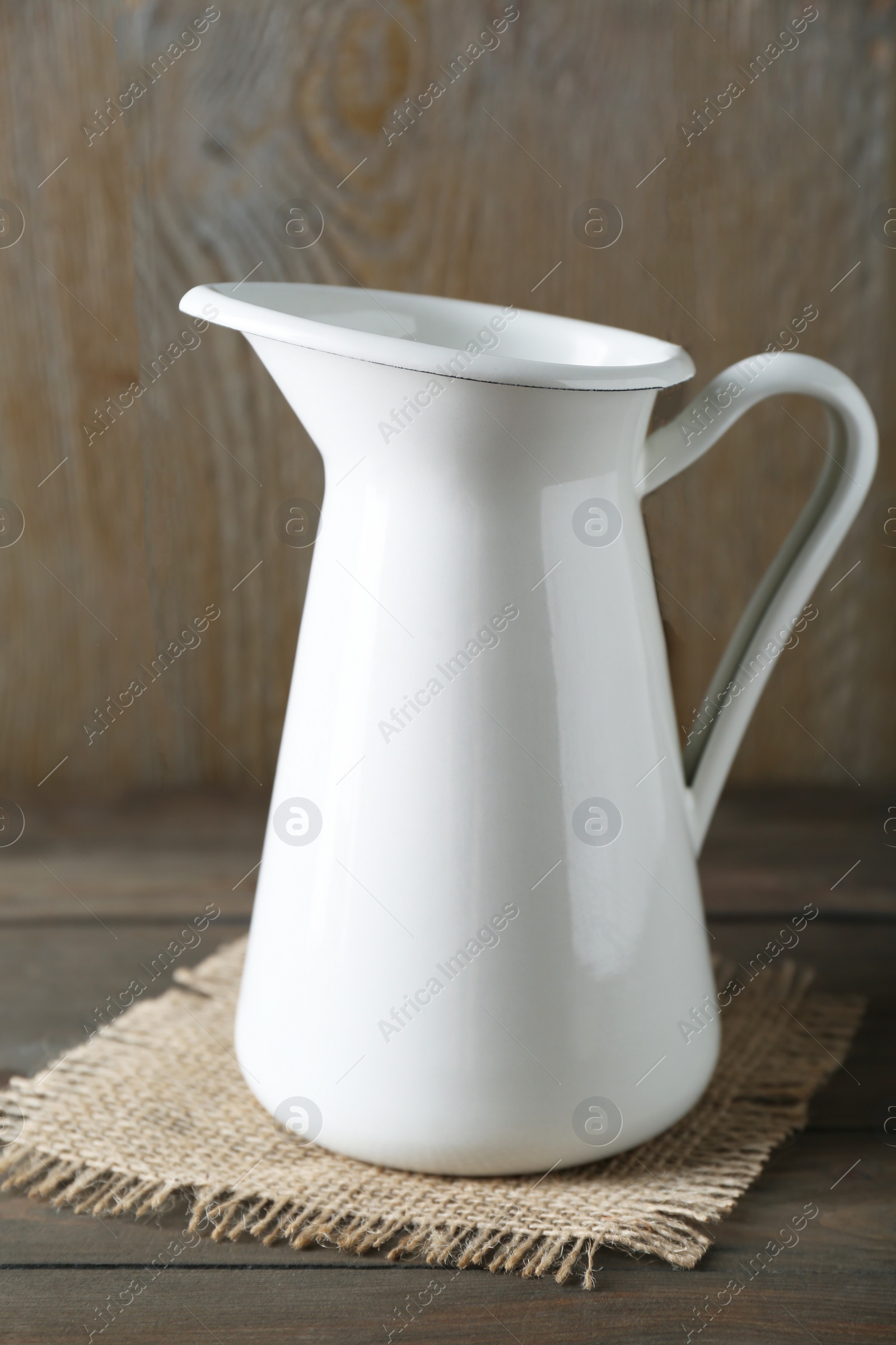 Photo of One beautiful white jug on wooden table