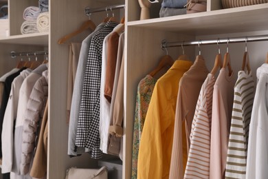 Photo of Wardrobe closet with different stylish clothes, accessories and home stuff