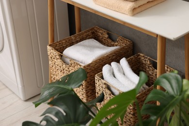 Photo of Storage baskets with folded white towels indoors