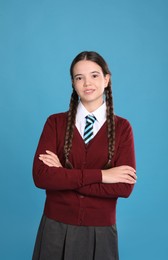 Photo of Teenage girl wearing school uniform on light blue background