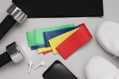 Photo of Flat lay composition with fitness elastic bands on light background