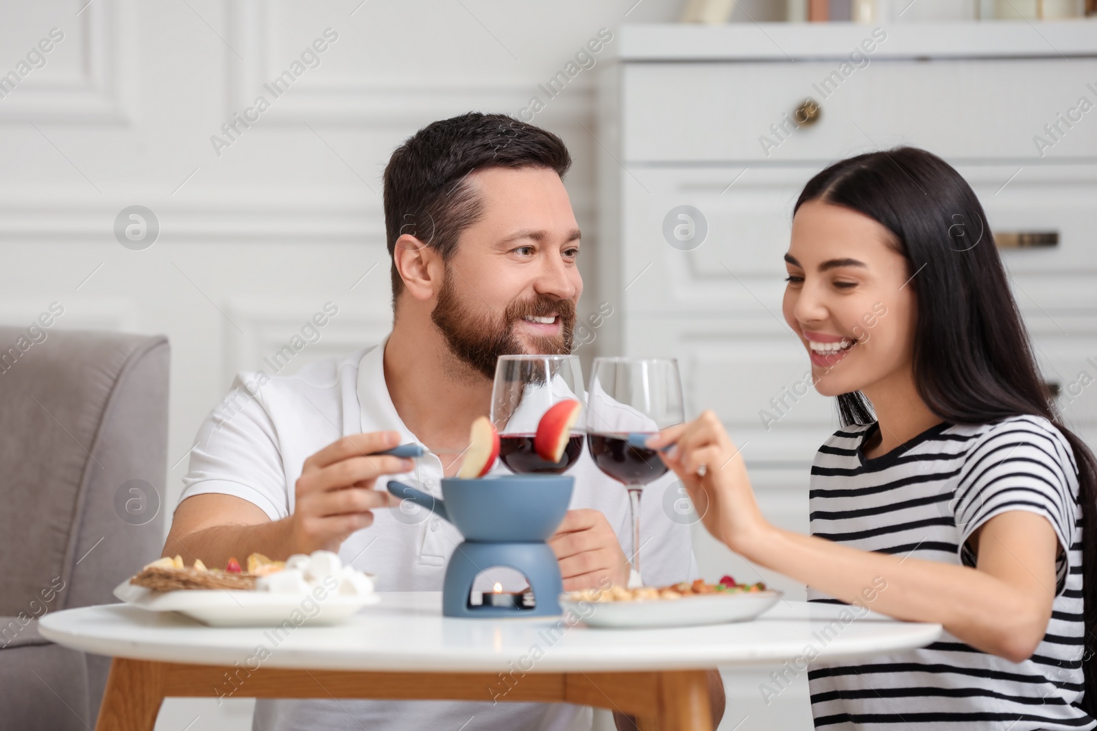 Photo of Affectionate couple enjoying fondue during romantic date at home