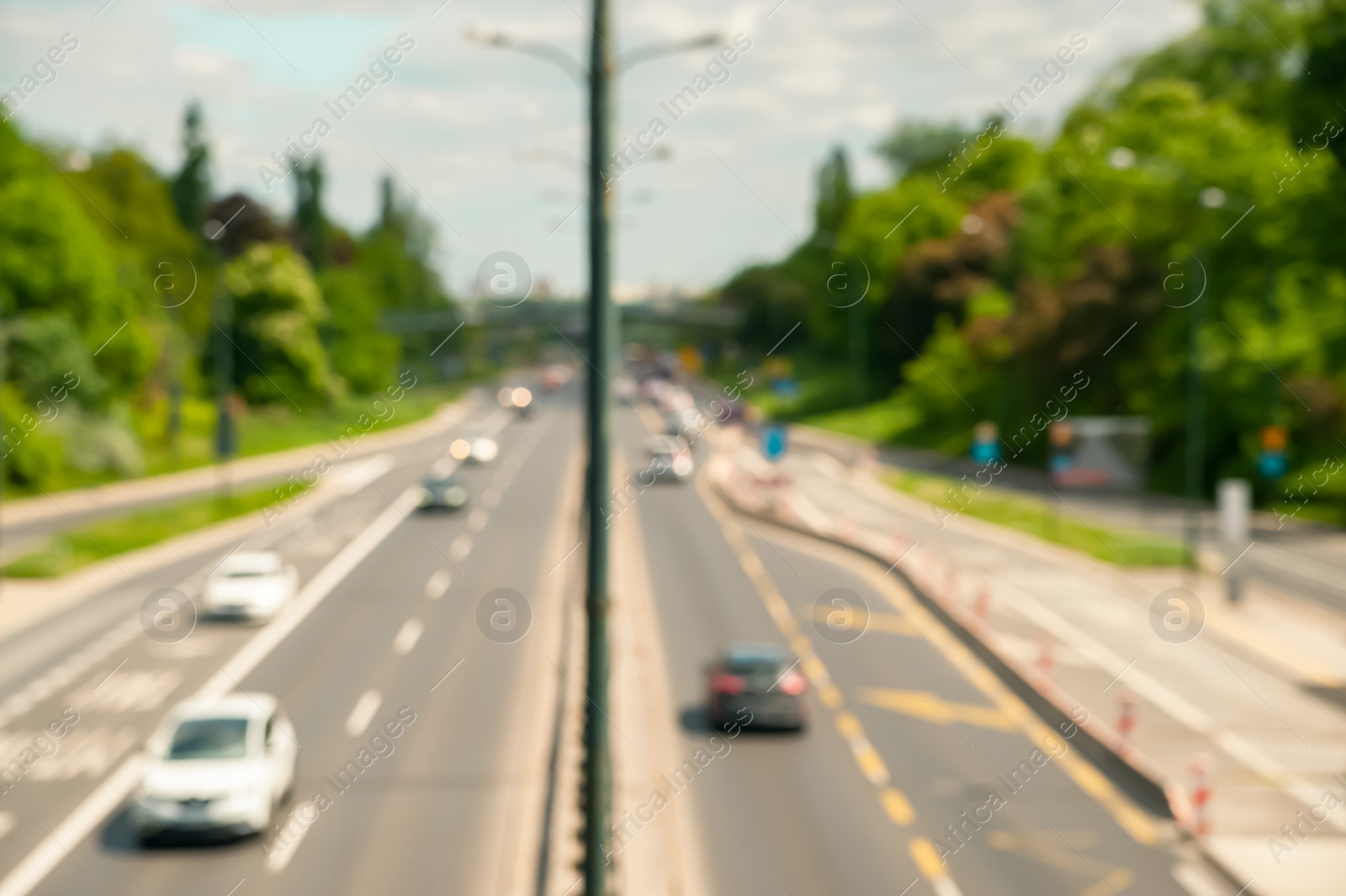 Photo of Blurred view of highway traffic with cars on sunny day