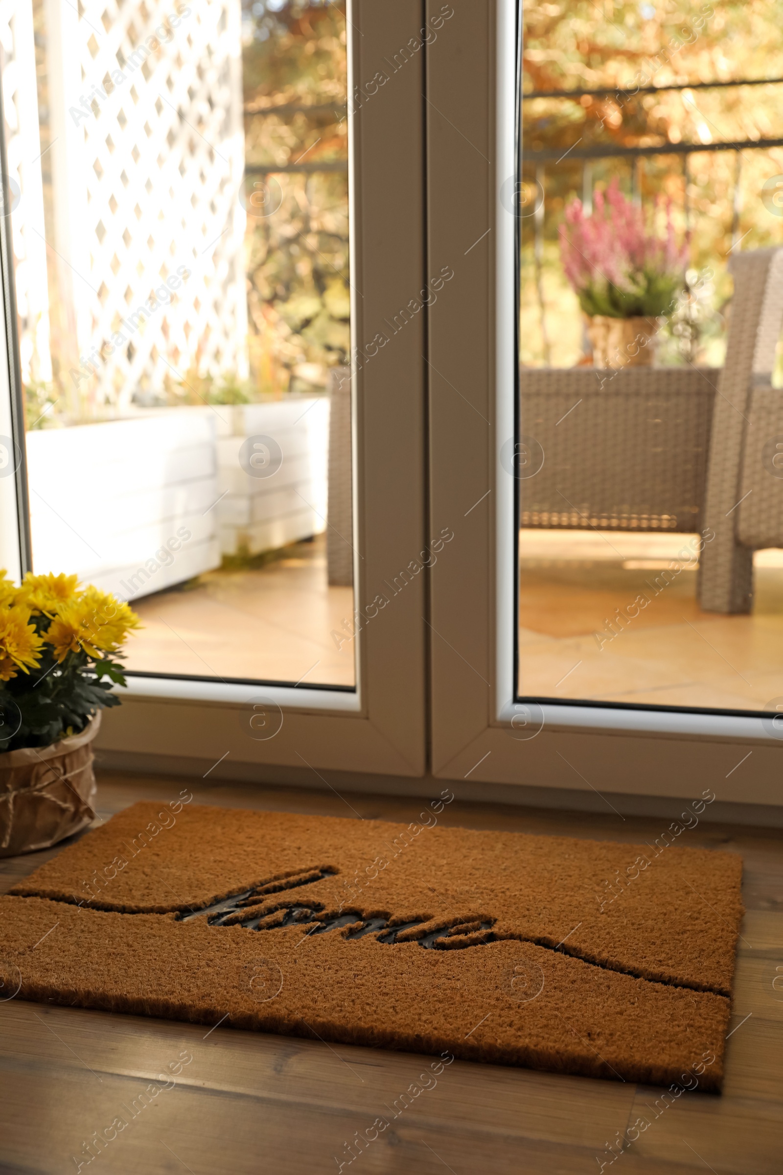 Photo of Doormat with word Home on parquet floor indoors