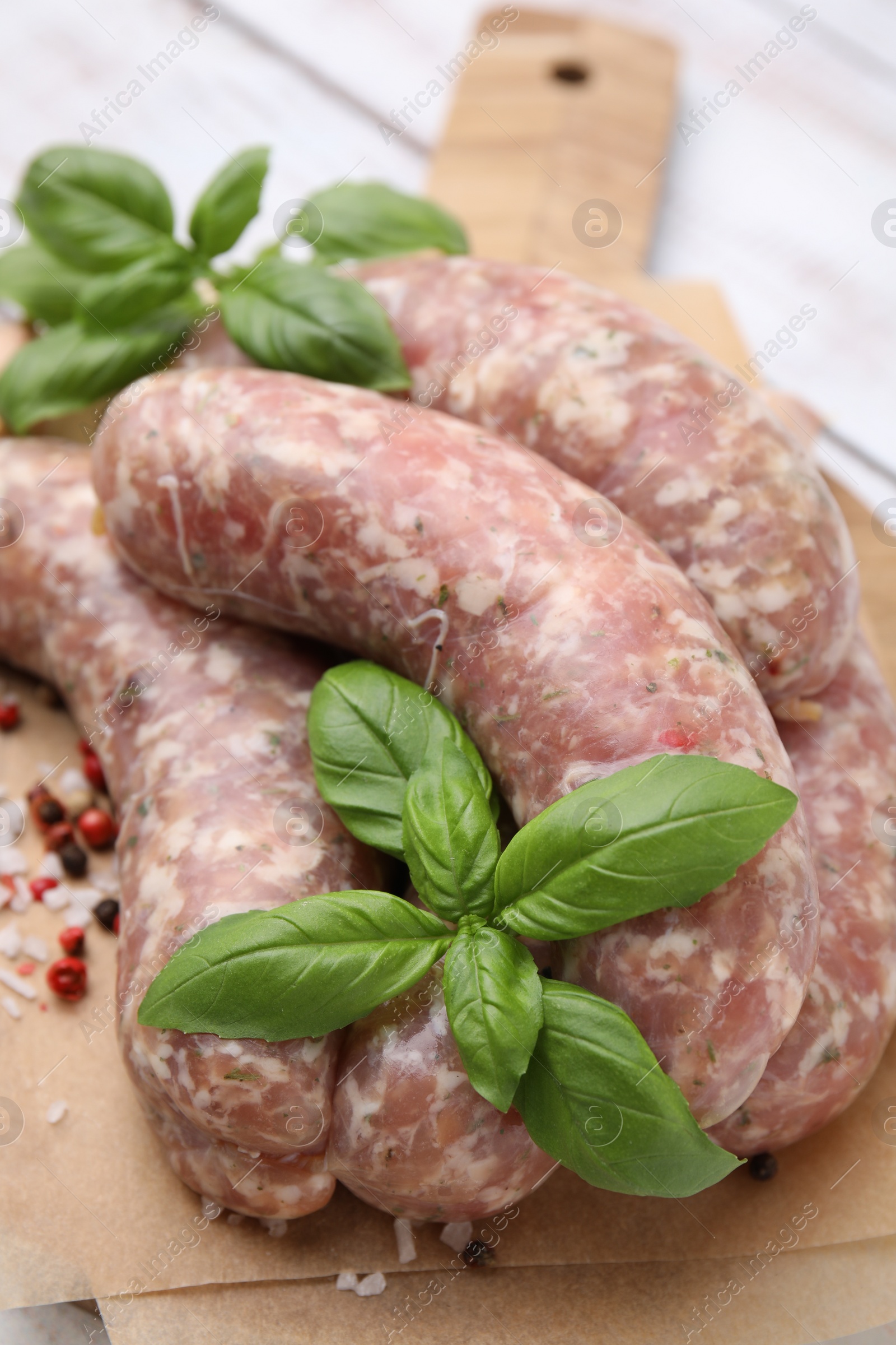 Photo of Raw homemade sausages and different spices on table, closeup