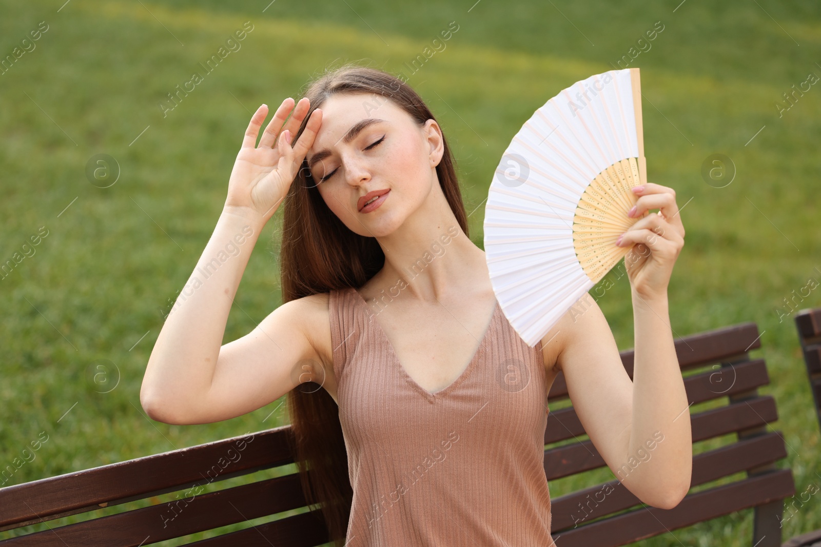 Photo of Woman with hand fan suffering from heat outdoors