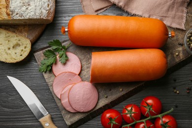 Photo of Flat lay composition with tasty boiled sausages on dark wooden table