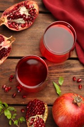 Photo of Tasty pomegranate juice in glasses and fresh fruits on wooden table, flat lay