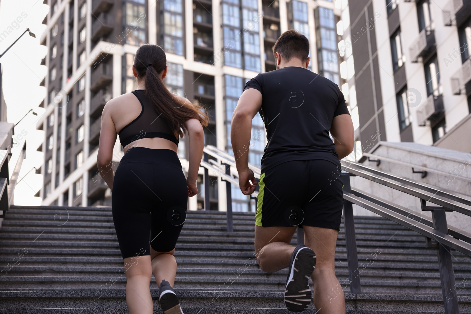 Photo of Healthy lifestyle. Couple running up steps outdoors, low angle view