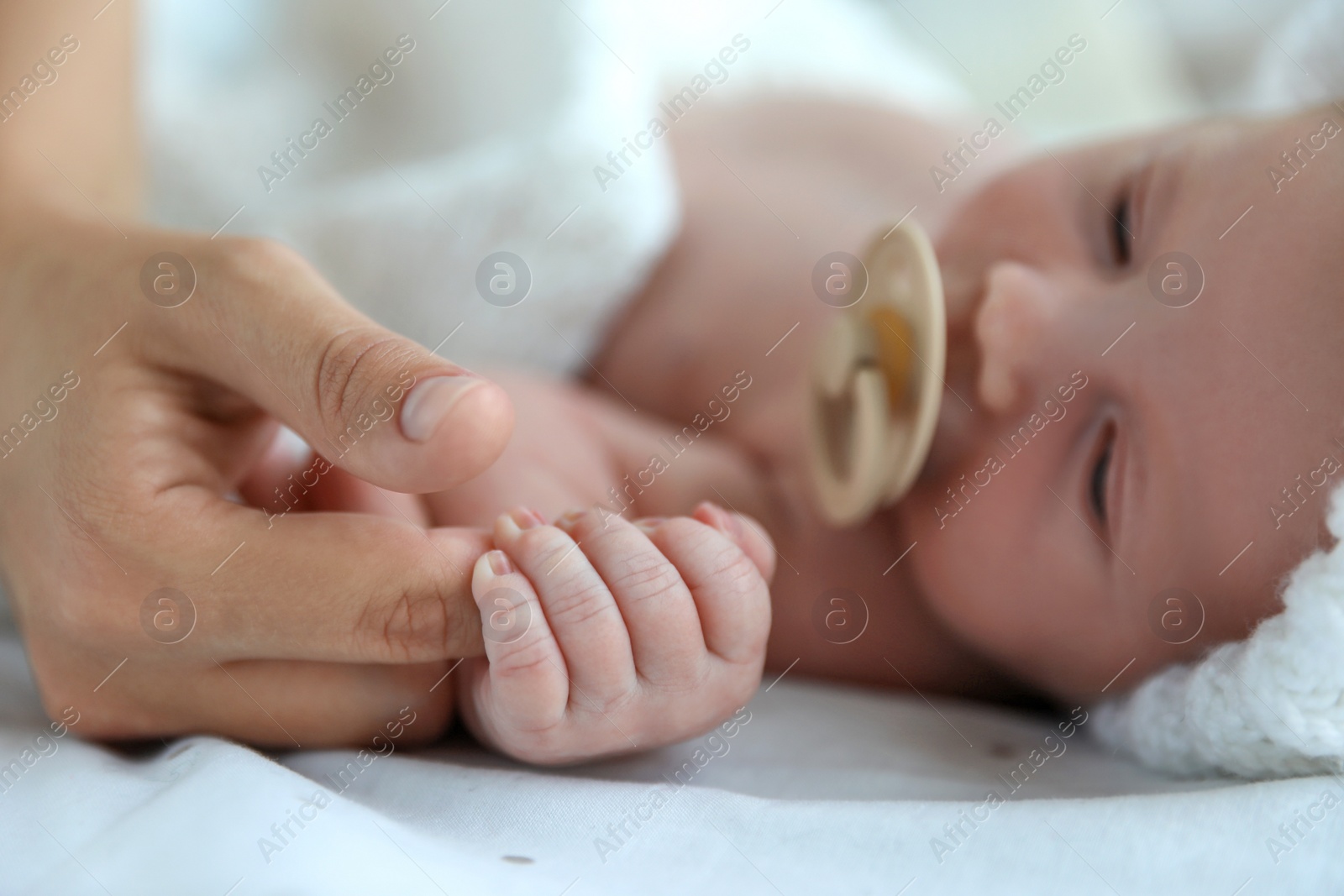 Photo of Mother and her cute newborn baby on bed, closeup