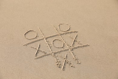 Tic tac toe game drawn on sandy beach, above view