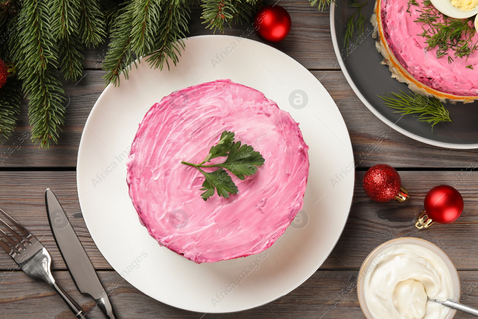 Photo of Herring under fur coat salad and Christmas decor served on wooden table, flat lay. Traditional Russian dish