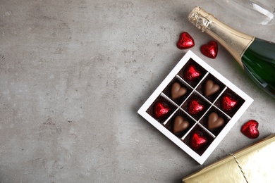 Photo of Flat lay composition with heart shaped chocolate candies on light grey table, space for text. Happy Valentine's day