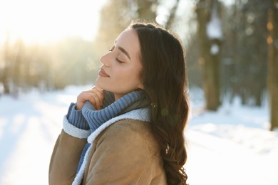 Photo of Portrait of beautiful woman in sunny snowy park