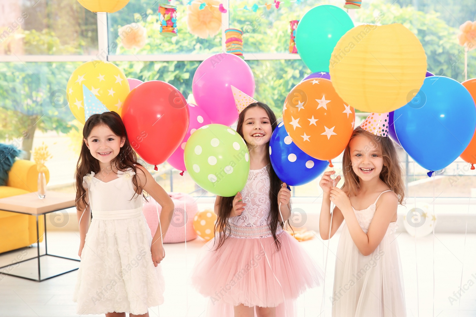 Photo of Cute girls with balloons at birthday party indoors