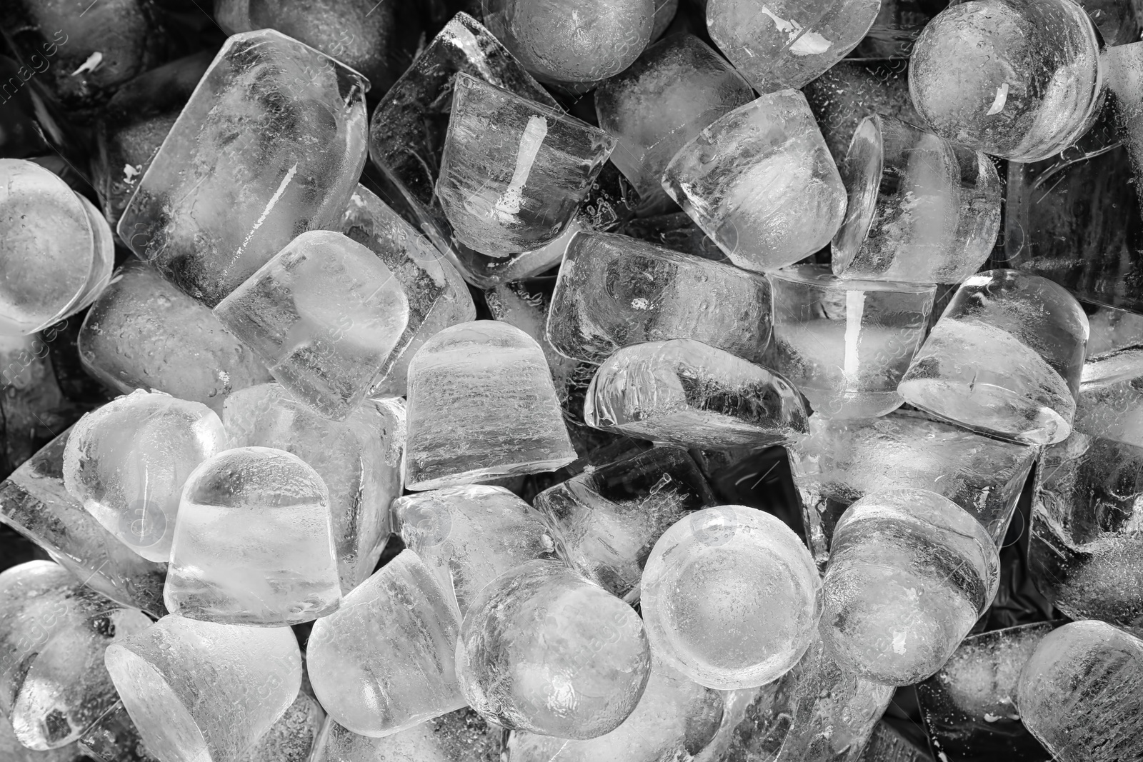 Photo of Many pieces of ice on black background, top view