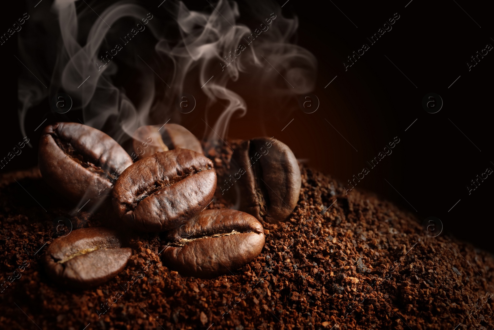 Image of Coffee grounds and roasted beans on dark background, closeup