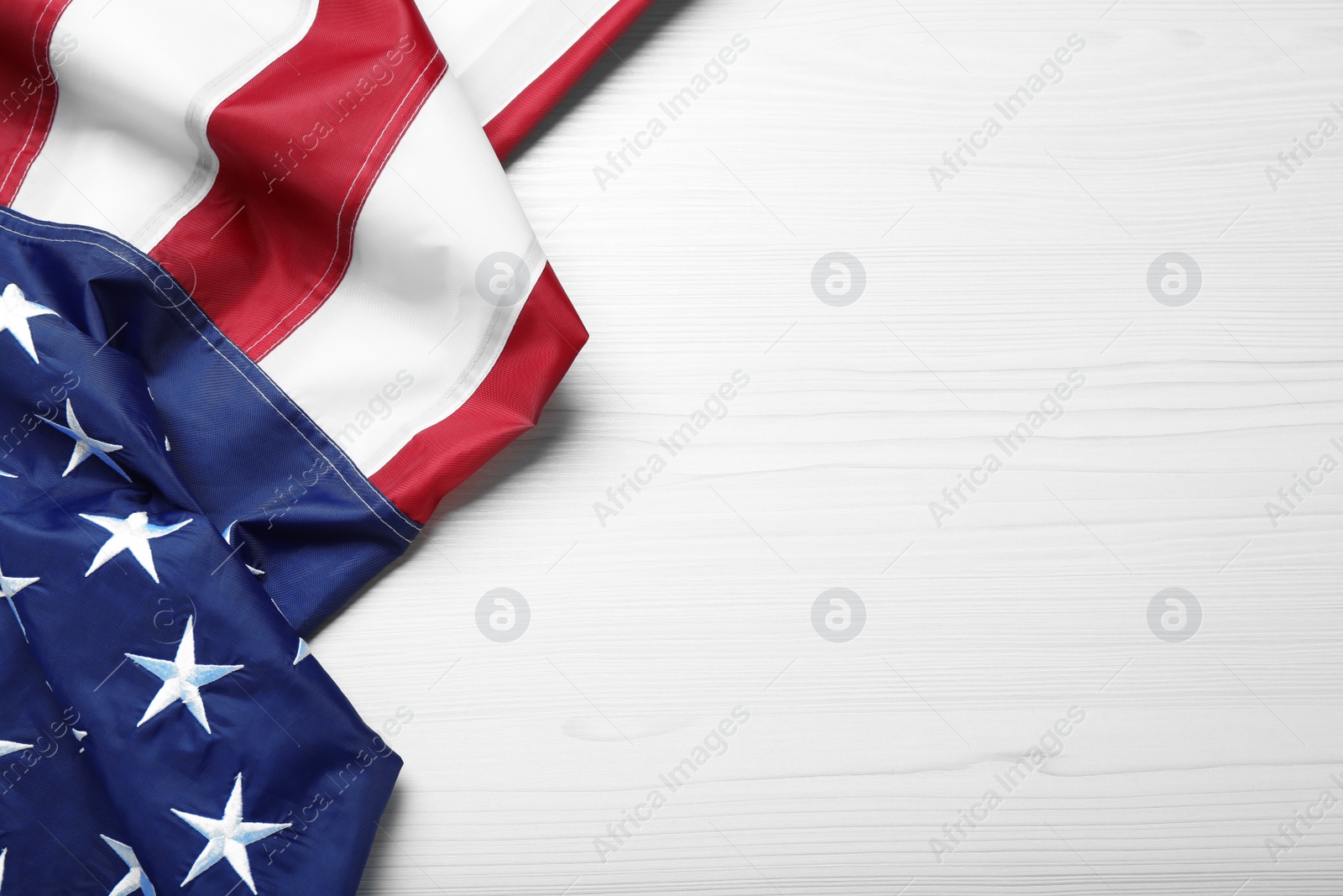 Photo of National flag of America and space for text on white wooden table, top view