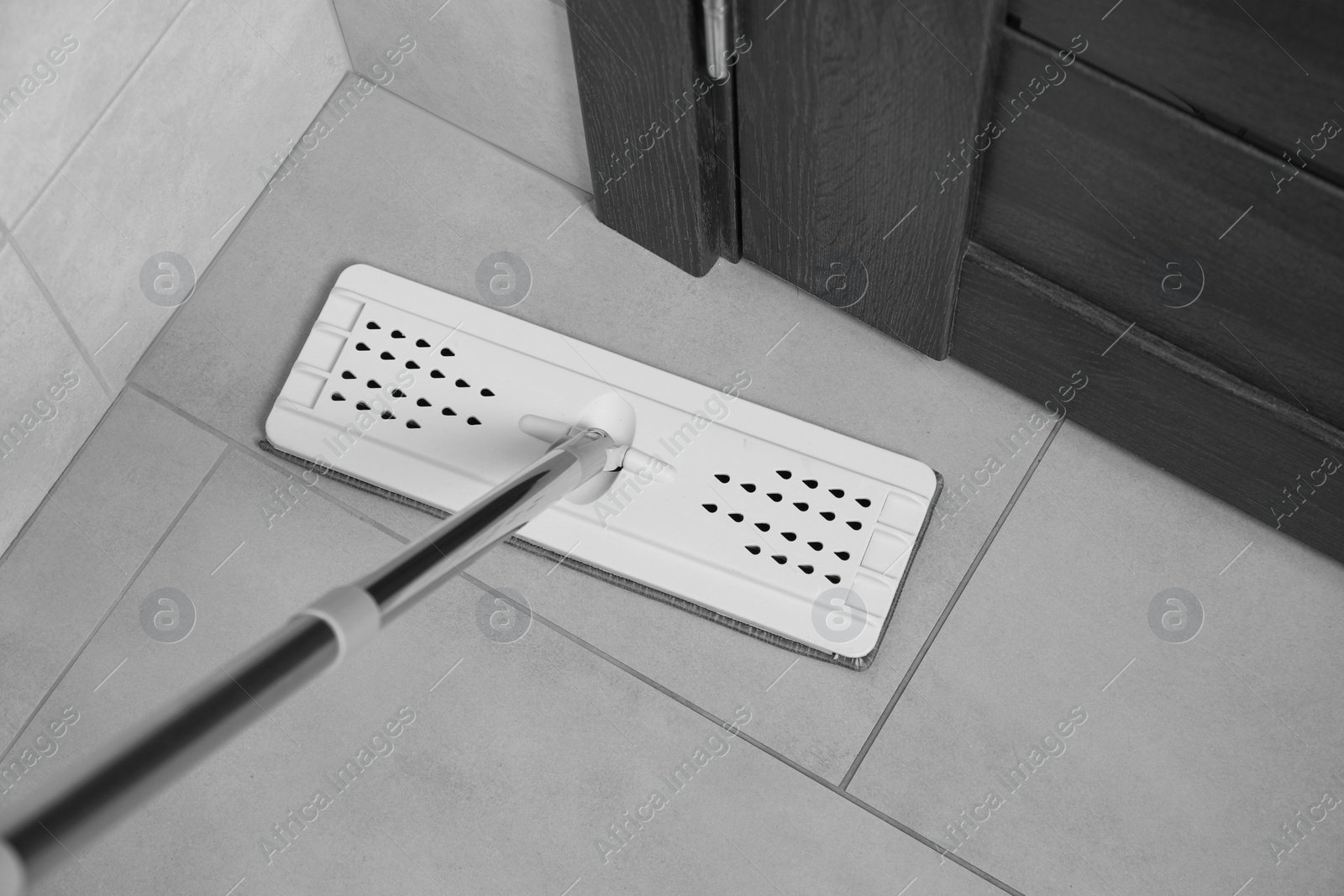 Photo of Cleaning grey tiled floor with mop, above view