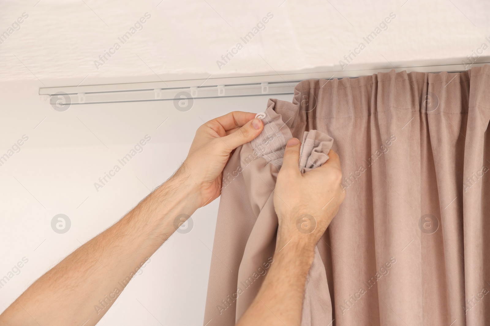 Photo of Worker hanging window curtain, closeup of hands