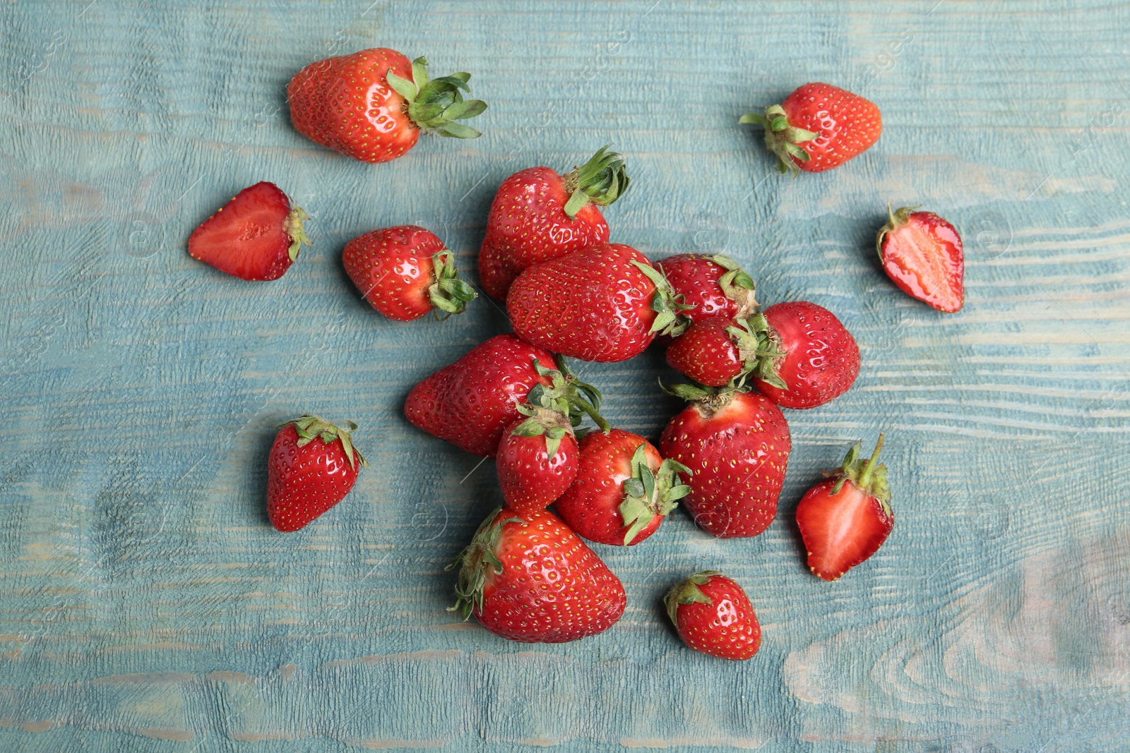 Photo of Delicious ripe strawberries on blue wooden table, flat lay