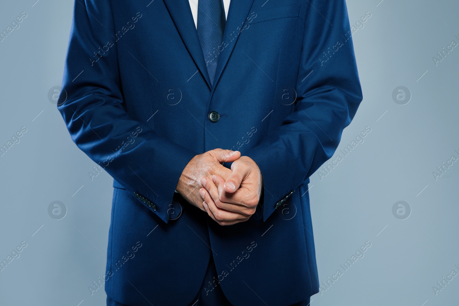 Photo of Businessman in elegant suit on grey background, closeup of hands