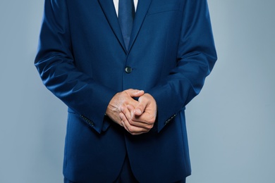 Photo of Businessman in elegant suit on grey background, closeup of hands