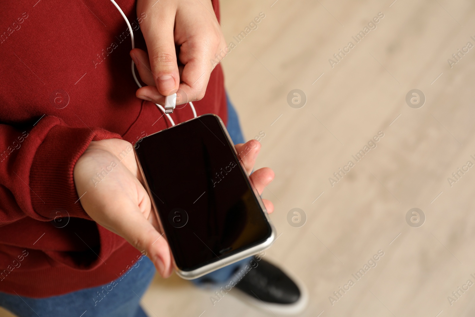 Photo of Man plugging headphones to smartphone indoors, closeup. Space for text