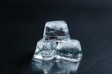 Photo of Ice cubes on wet black surface, closeup