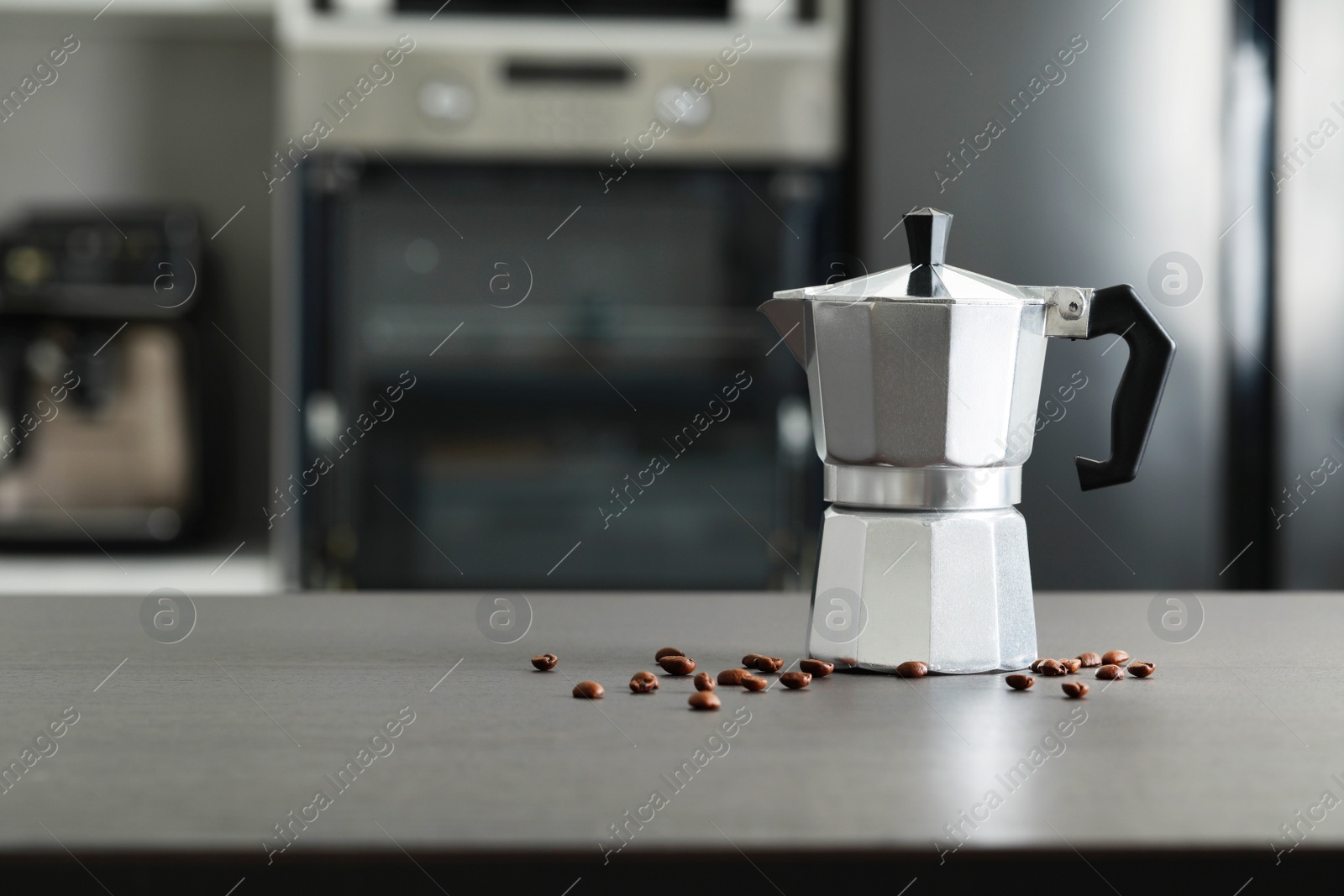 Photo of Moka pot and coffee beans on grey table in kitchen. Space for text