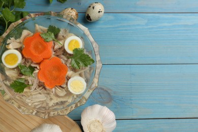 Delicious aspic with meat and vegetables served on light blue wooden table, flat lay. Space for text