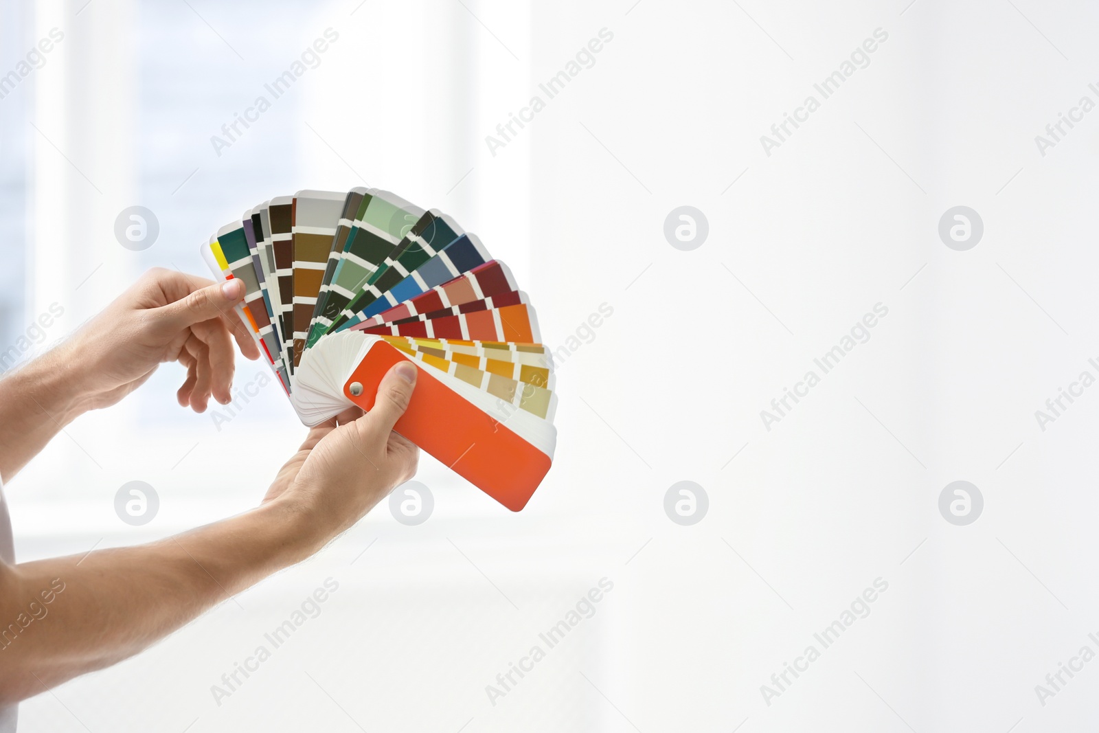 Photo of Professional interior designer with color palette on light background, closeup. Space for text