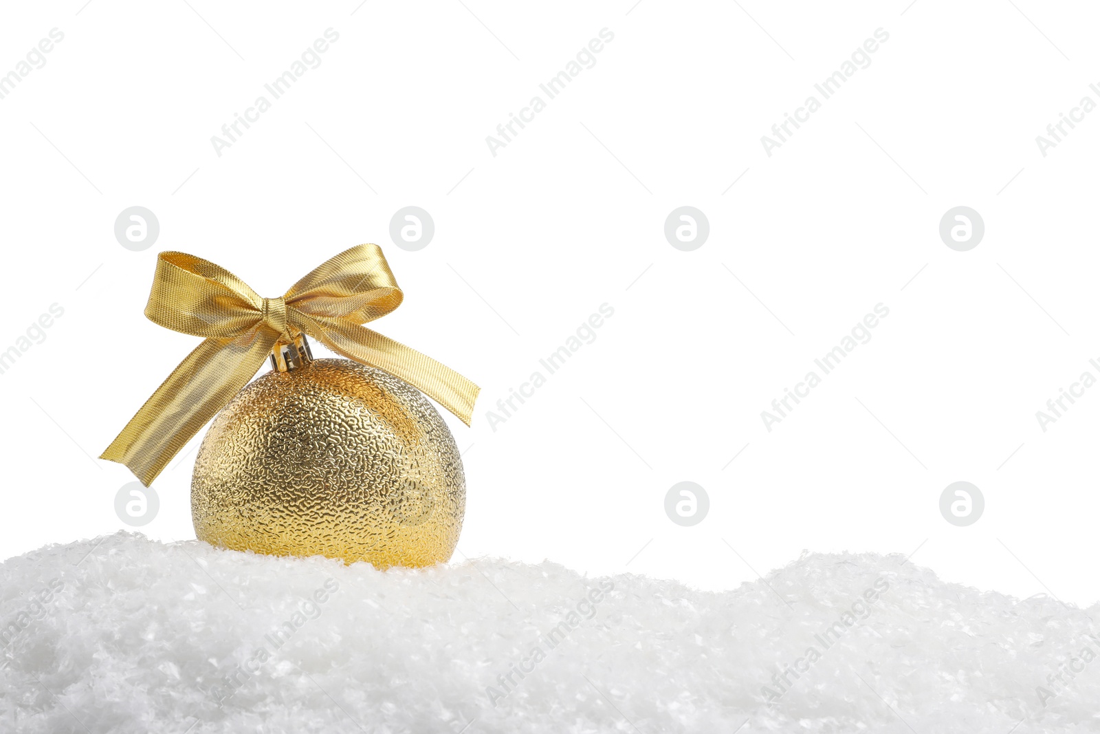 Photo of Beautiful golden Christmas ball with bow on snow against white background