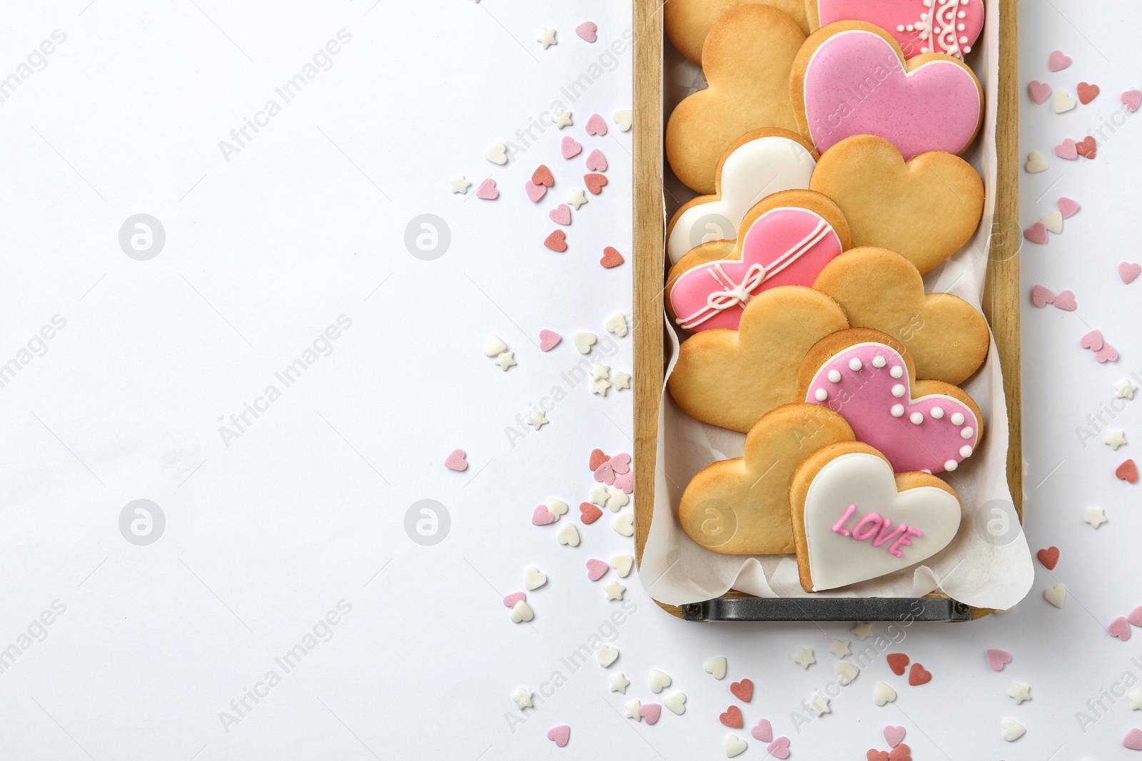 Photo of Tray with decorated heart shaped cookies and space for text on white background, top view