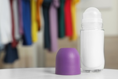 Photo of Roll-on deodorant on table against blurred background. Space for design