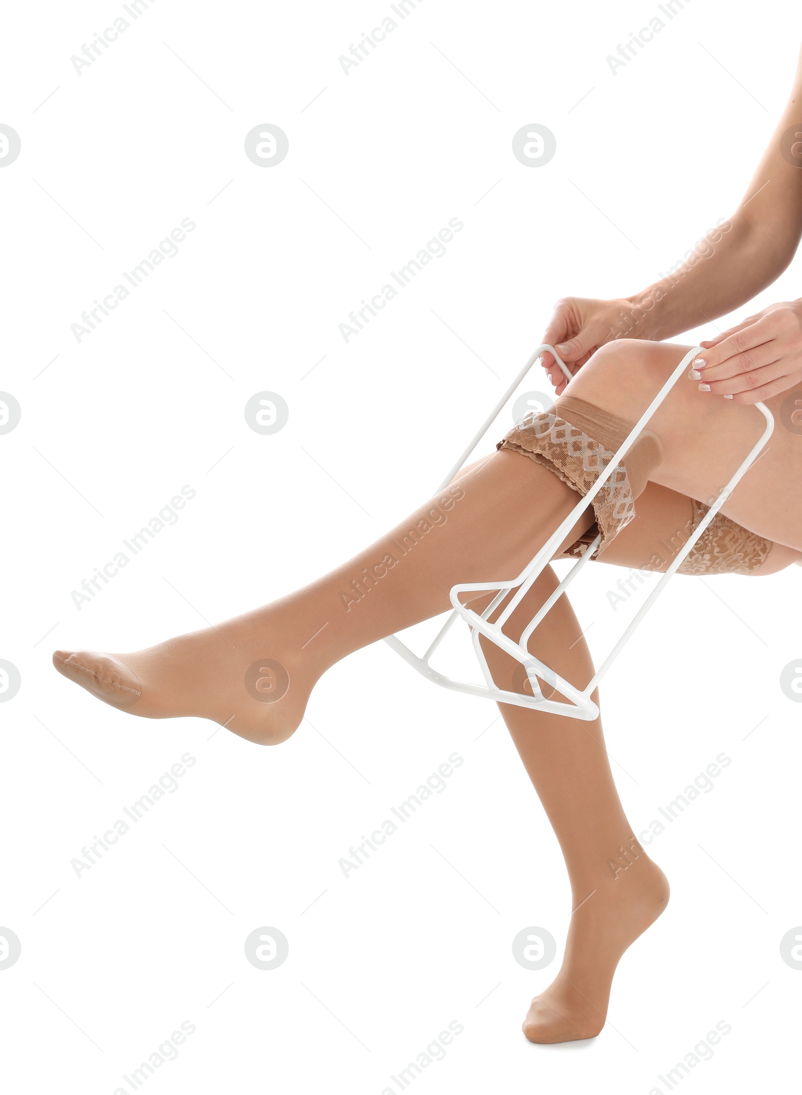 Photo of Woman putting on compression garment with stocking donner against white background, closeup