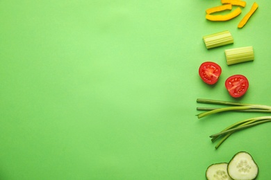 Photo of Flat lay composition with fresh salad ingredients on green background, space for text