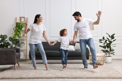 Happy family dancing and having fun in living room