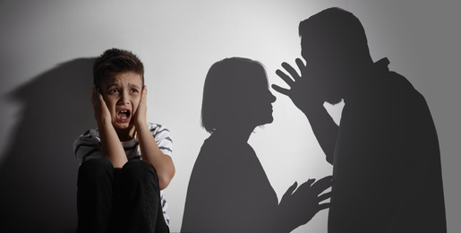 Image of Scared little boy closing his ears and silhouettes of arguing parents. Banner design
