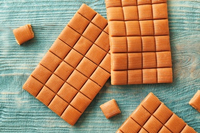 Photo of Delicious caramel candies on wooden background