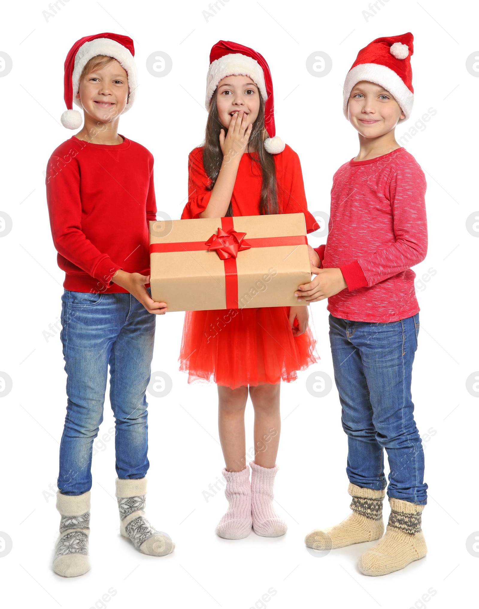 Photo of Cute little children in Santa hats with Christmas gift box on white background